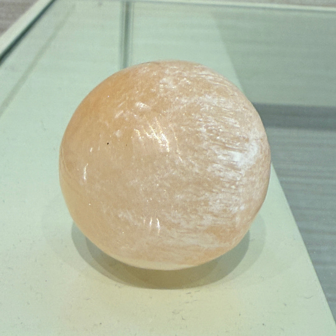 Peach Selenite Sphere with soft warm glow, symbolizing emotional healing and renewal.