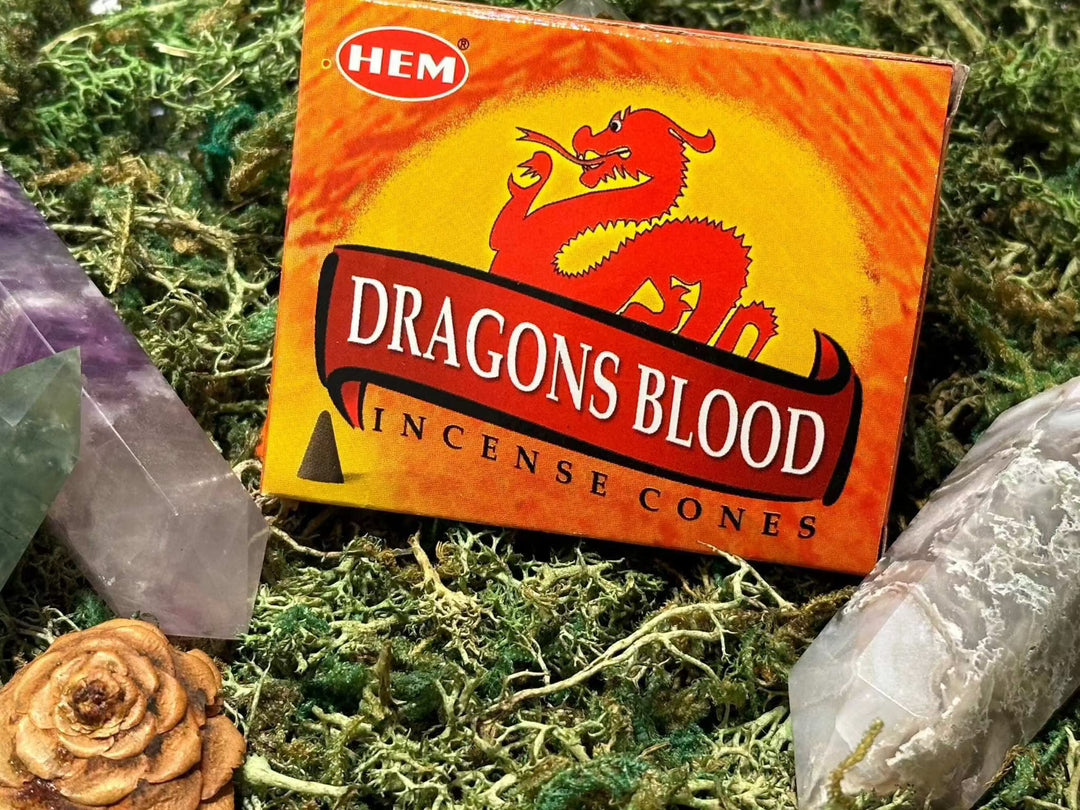 HEM Dragons Blood Incense Cones box with vibrant design on moss surface, surrounded by crystals.