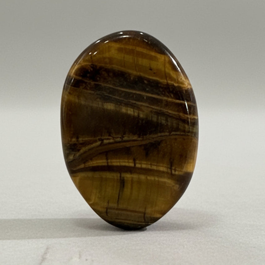 Tiger Eye Comfort Stone with golden shimmer and bands, symbolizing strength and courage.
