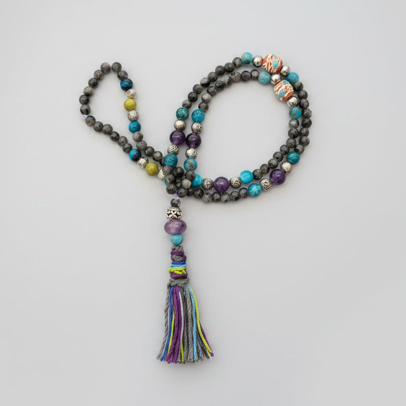 Colorful beaded necklace with a tassel on a decorative stone background