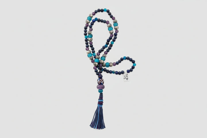 Multicolored beaded necklace with tassel on a decorative stone surface
