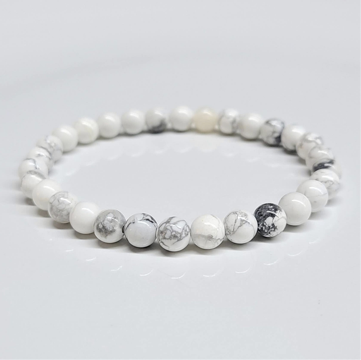 Howlite stackable bracelet with round white beads featuring gray veining for calming and stress relief.