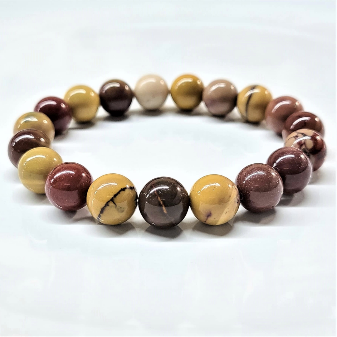 Mookaite stackable bracelet with polished round multicolored beads in earth tones, 7.5-inch fit, promoting harmony and balance.