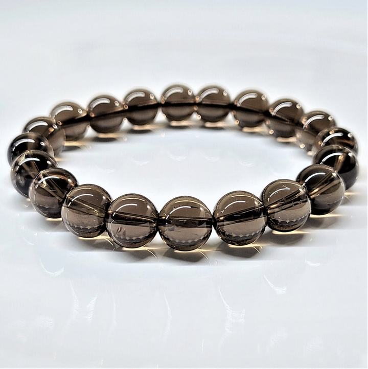 Smokey Quartz round bead stretch bracelet with translucent brown beads for grounding and protection.