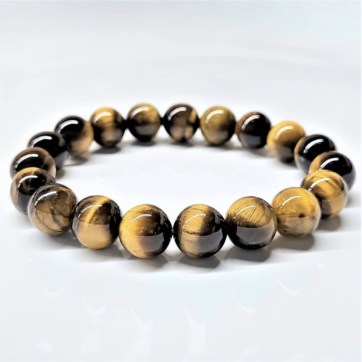 Tiger Eye stackable bracelet with polished round golden-brown and black beads, symbolizing courage and clarity.