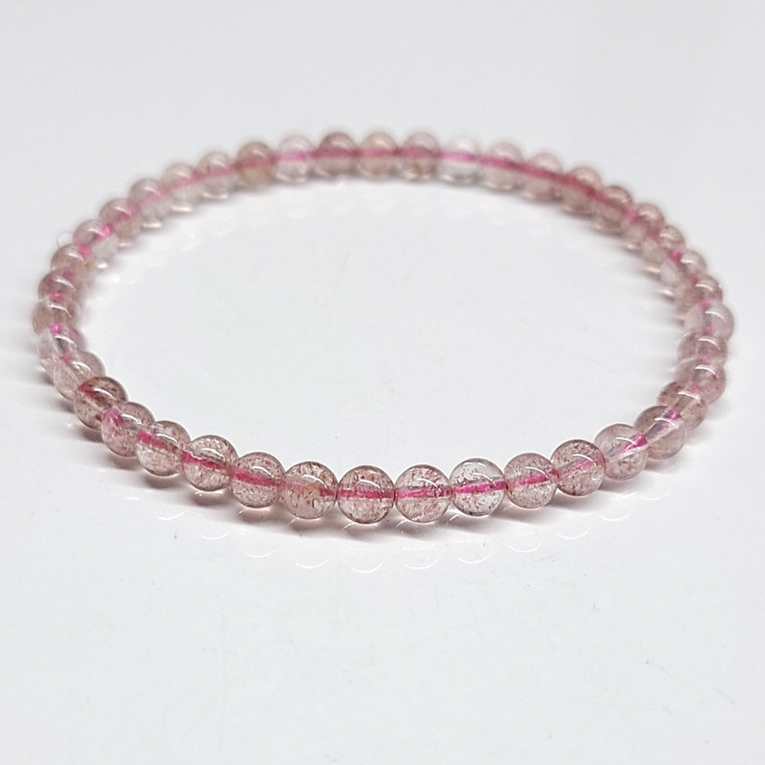 Strawberry Quartz Bracelet featuring delicate 4mm beads in pinkish-red hues, known for its aesthetic and metaphysical properties linked to love and healing.