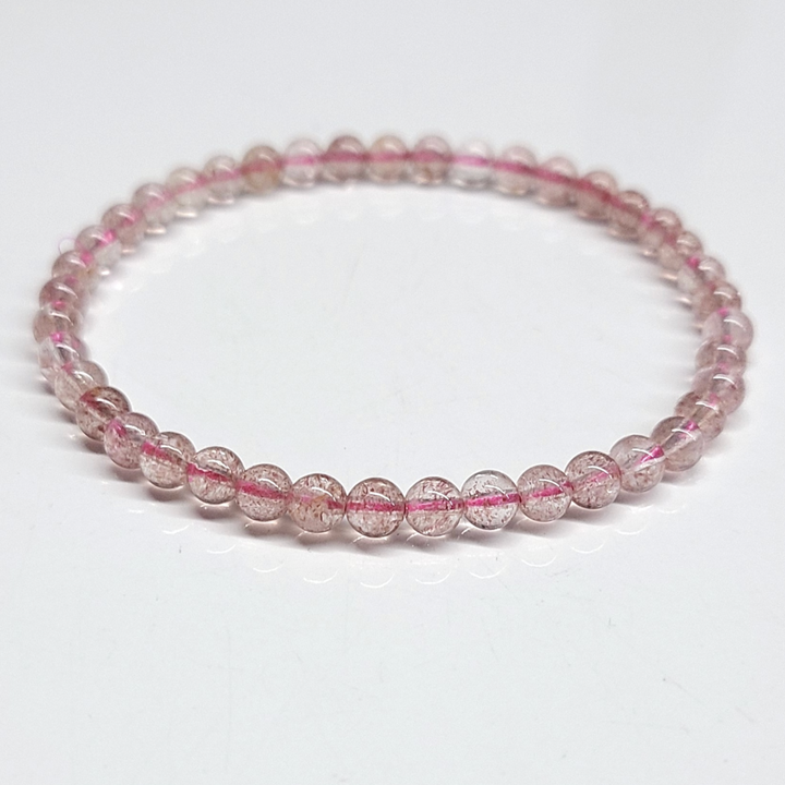 Strawberry Quartz Bracelet featuring delicate 4mm beads in pinkish-red hues, known for its aesthetic and metaphysical properties linked to love and healing.