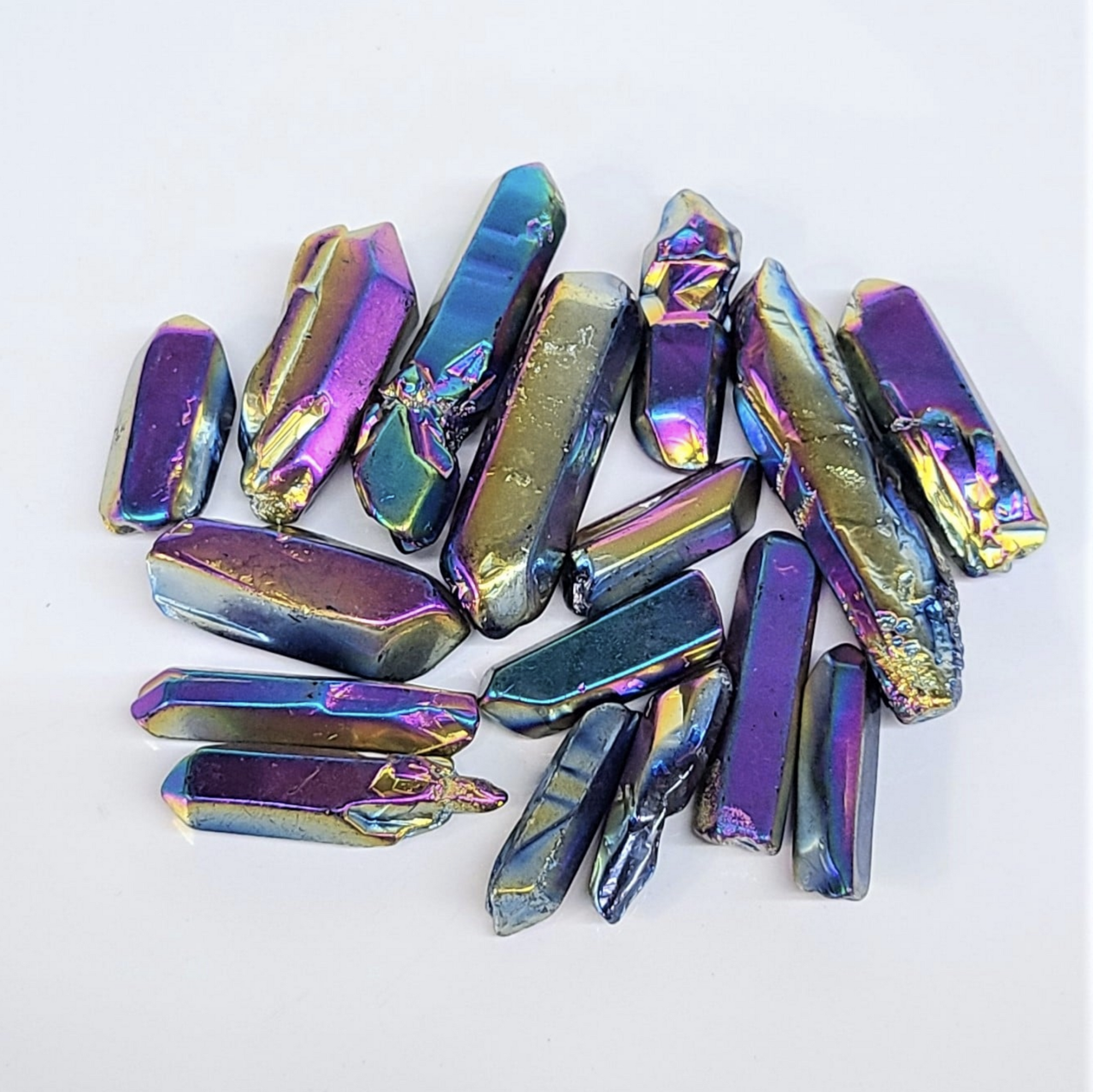 Multicolored titanium quartz points arranged on a white background.