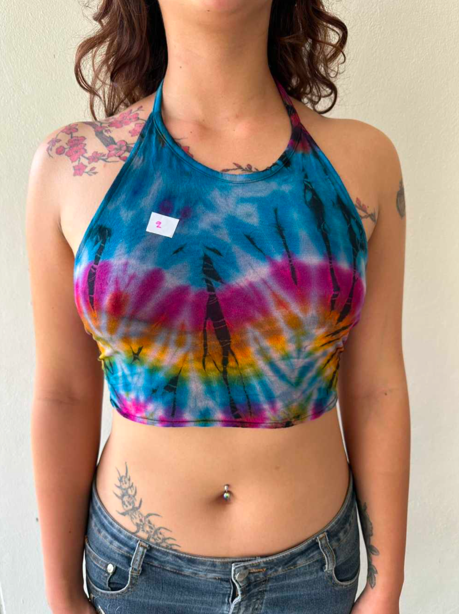 Colorful tie dye halter crop top in boho festival style with a flattering fitted design.
