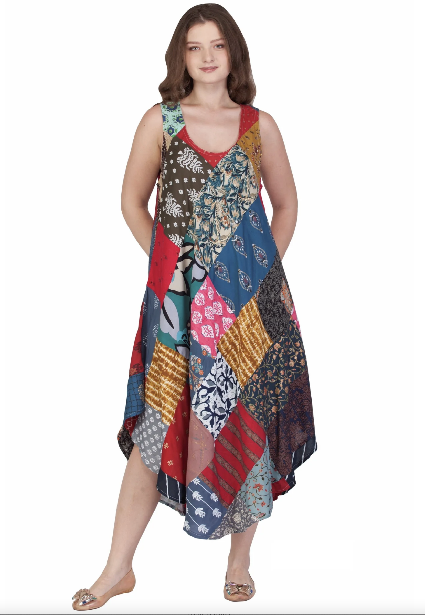 Woman wearing colorful sleeveless patchwork dress with varied patterns and asymmetrical hem