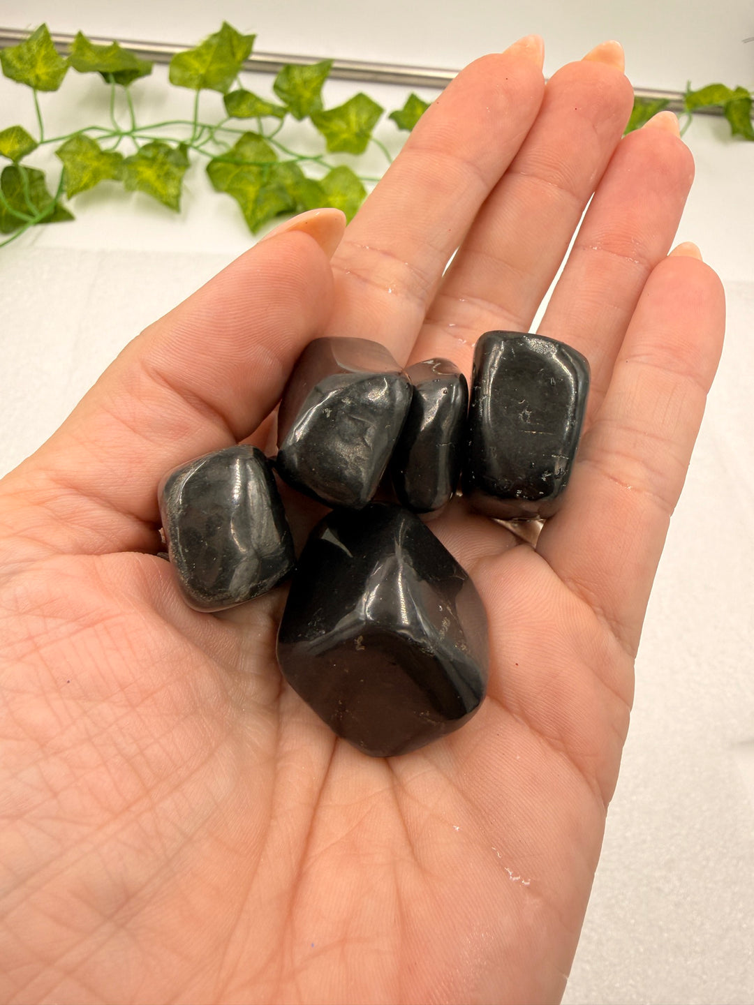 Shungite tumbled stones held in hand