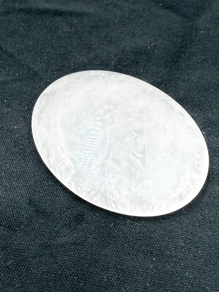 Clear quartz comfort stone on dark cloth, close-up