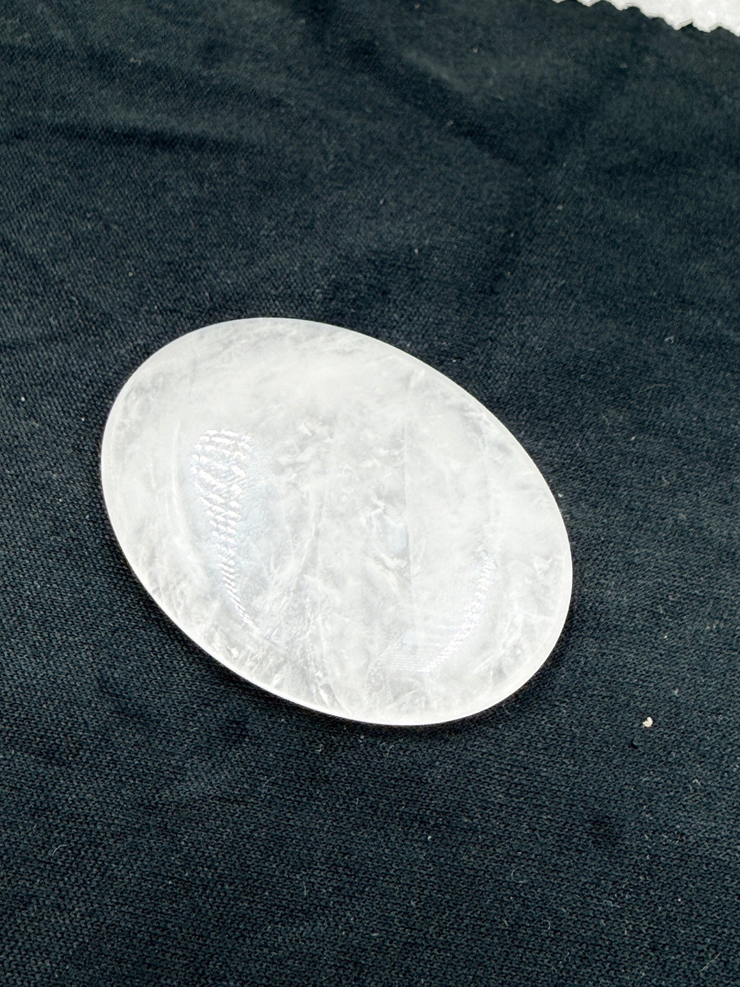Clear quartz comfort stone on dark cloth, detail of the surface