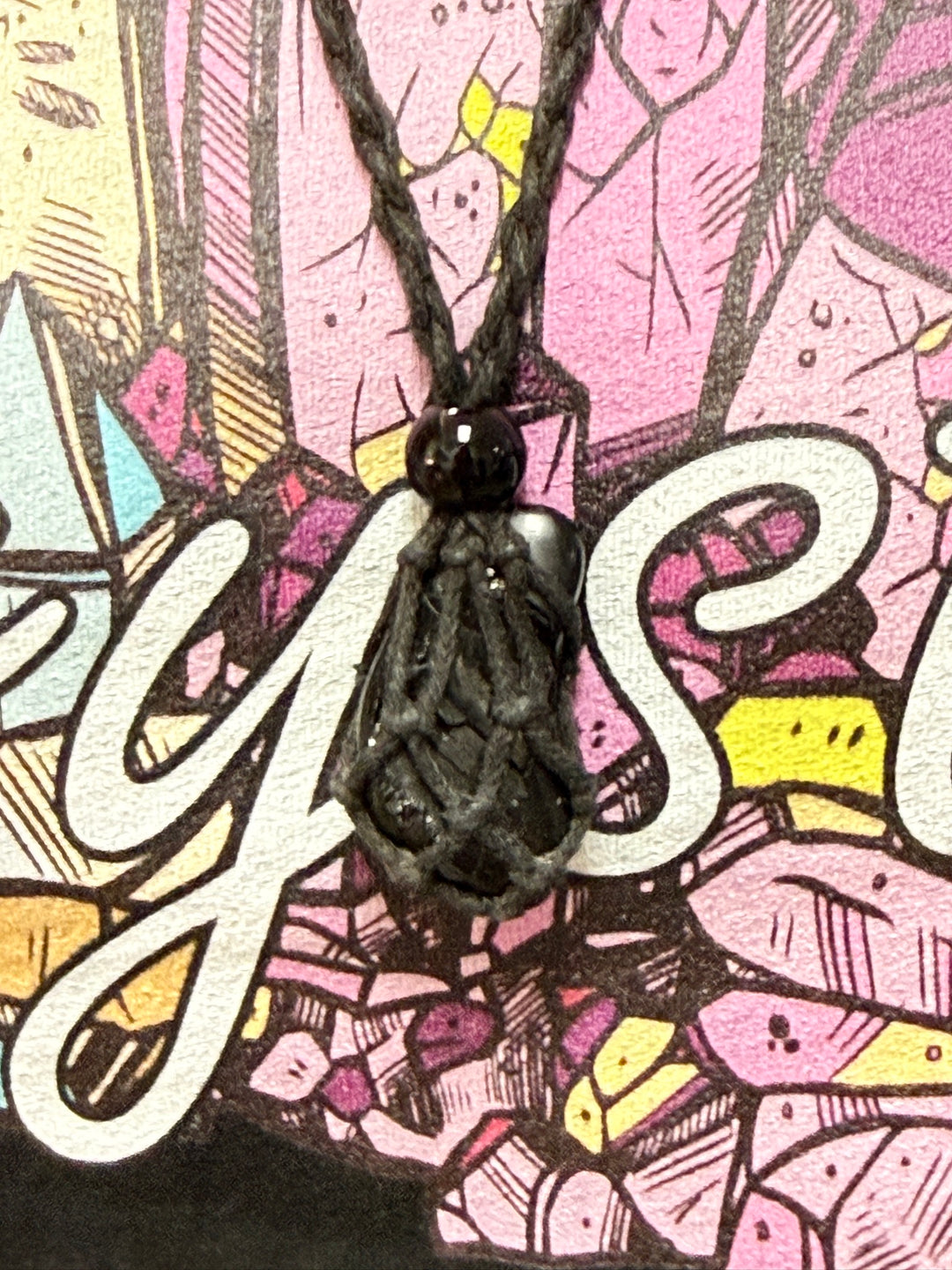 Crystal net necklace holding a dark stone, close-up
