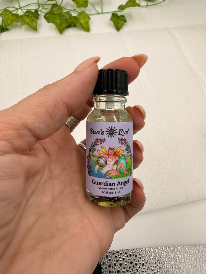 Guardian Angel Oil .5 oz bottle held in hand for scale