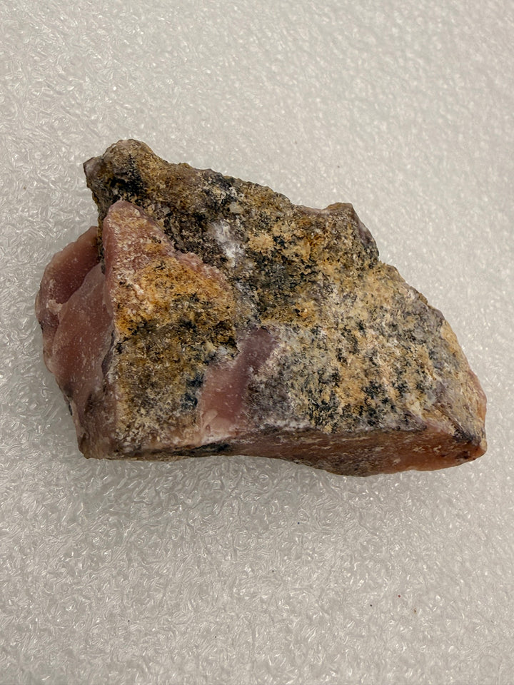 Cherry opal rough pocket stone, close-up of the raw texture