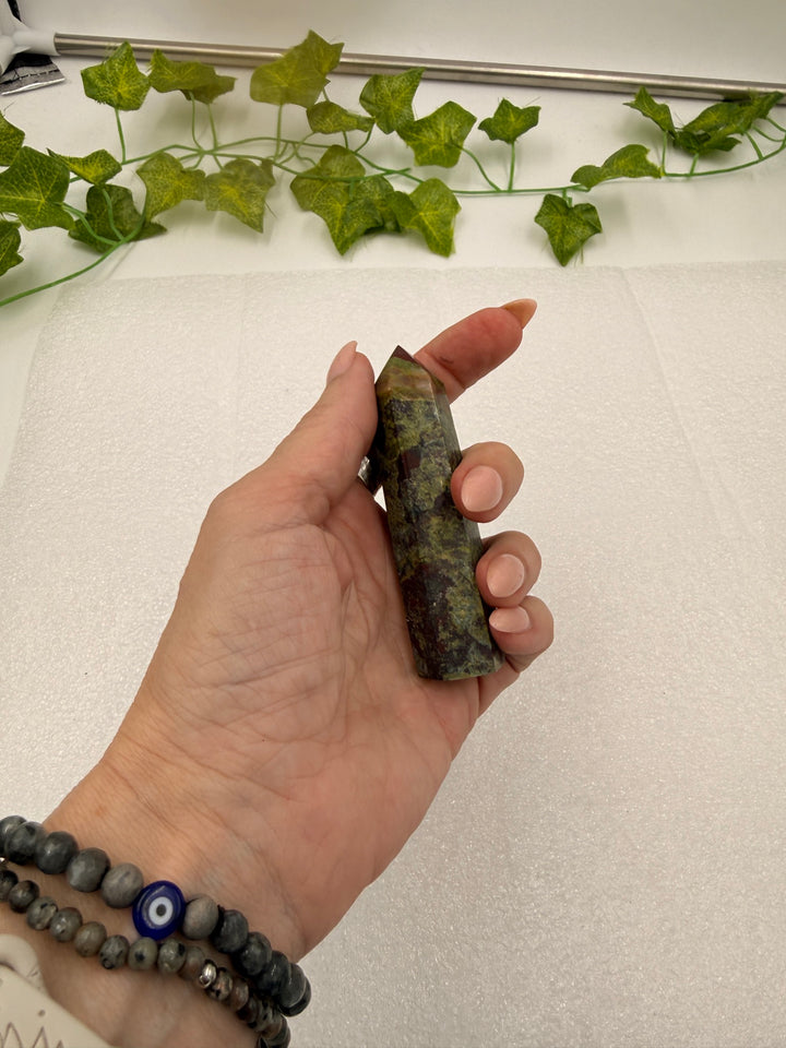 Dragon Blood Jasper tower lying across the palm for scale