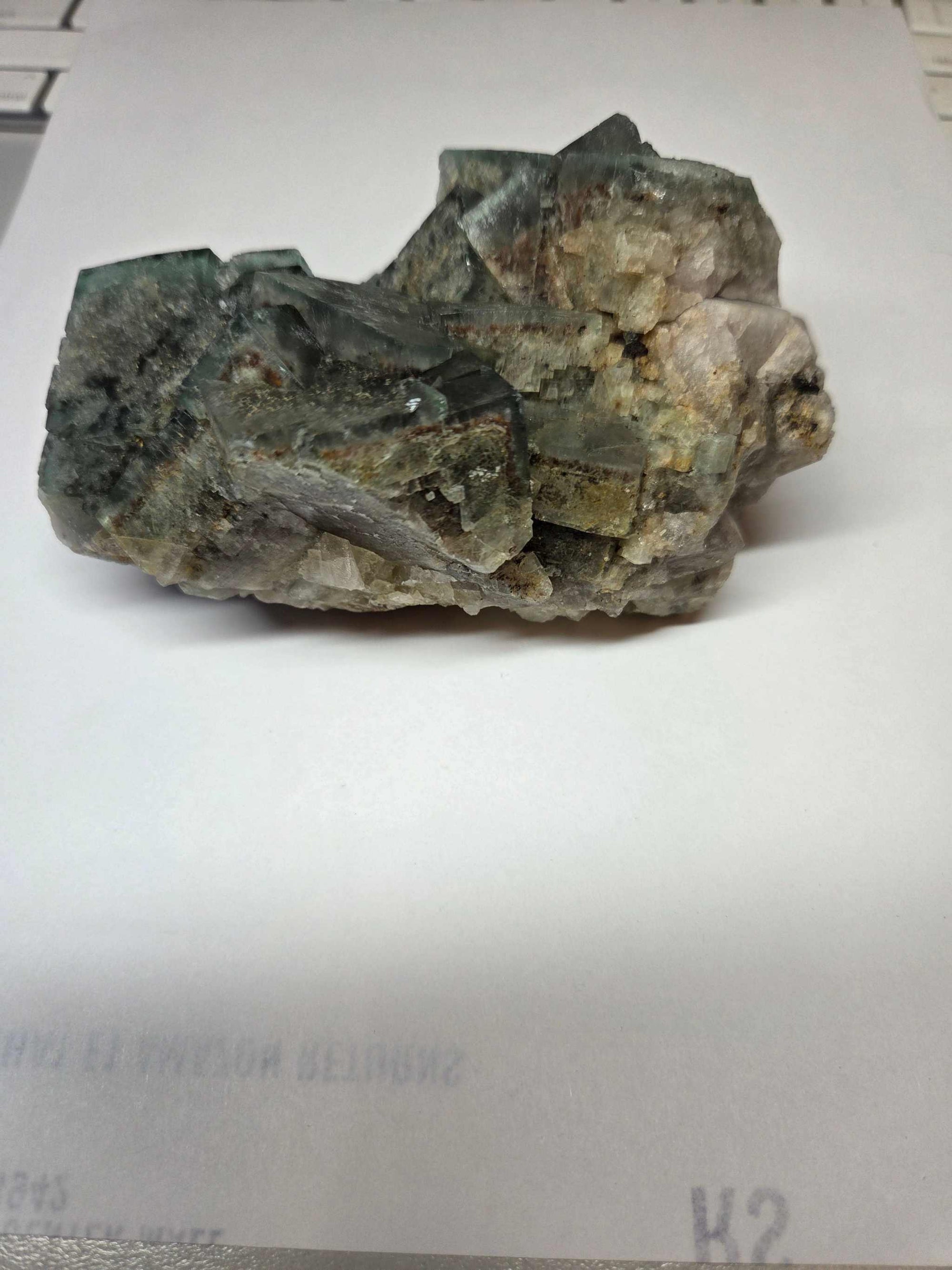 Green Fluorite specimen with yellow fluorite inclusions on a white background