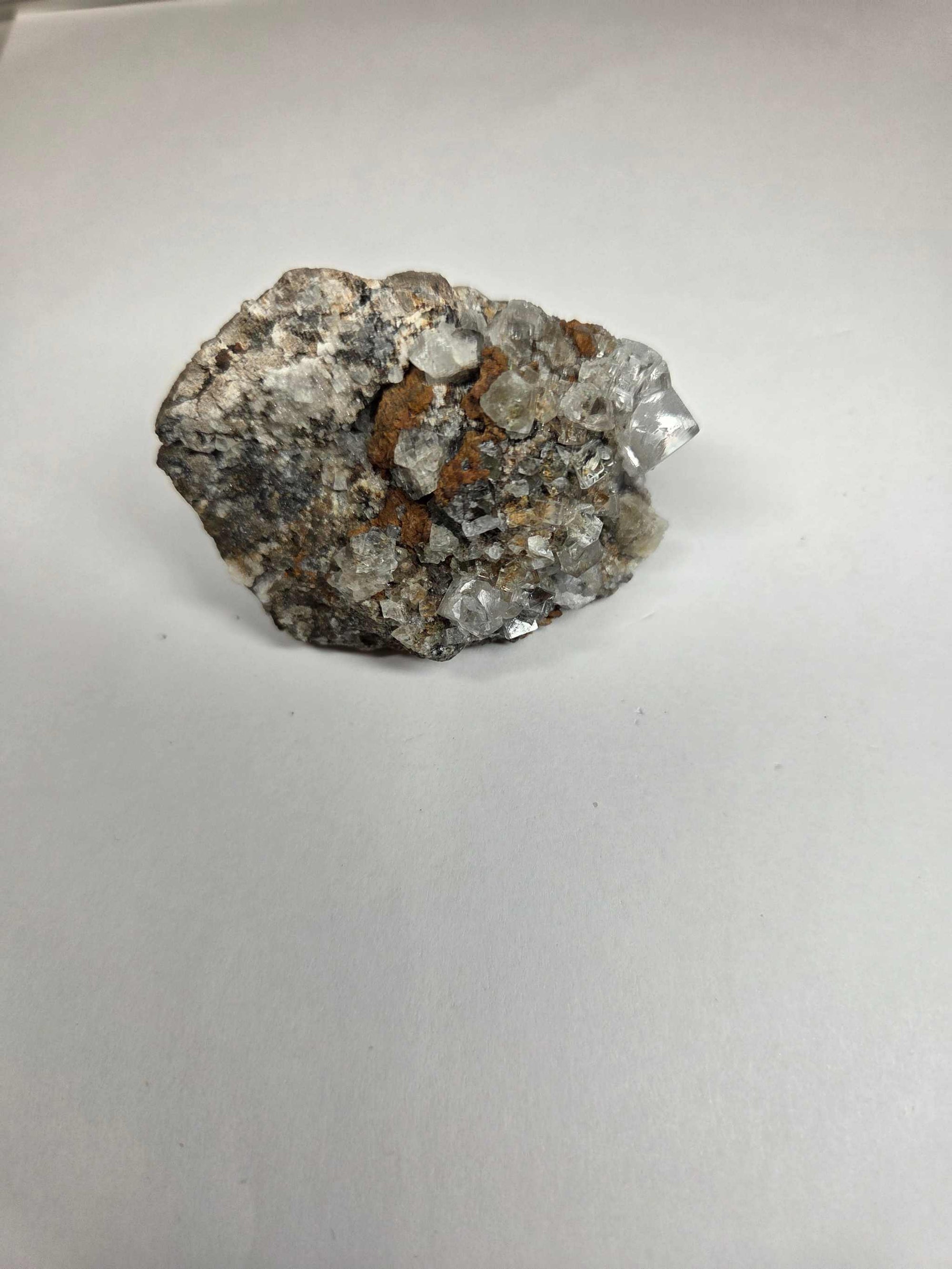 Clear Fluorite with Iron-Stained Matrix crystal specimen showcasing clear and earthy mineral formations on a white background