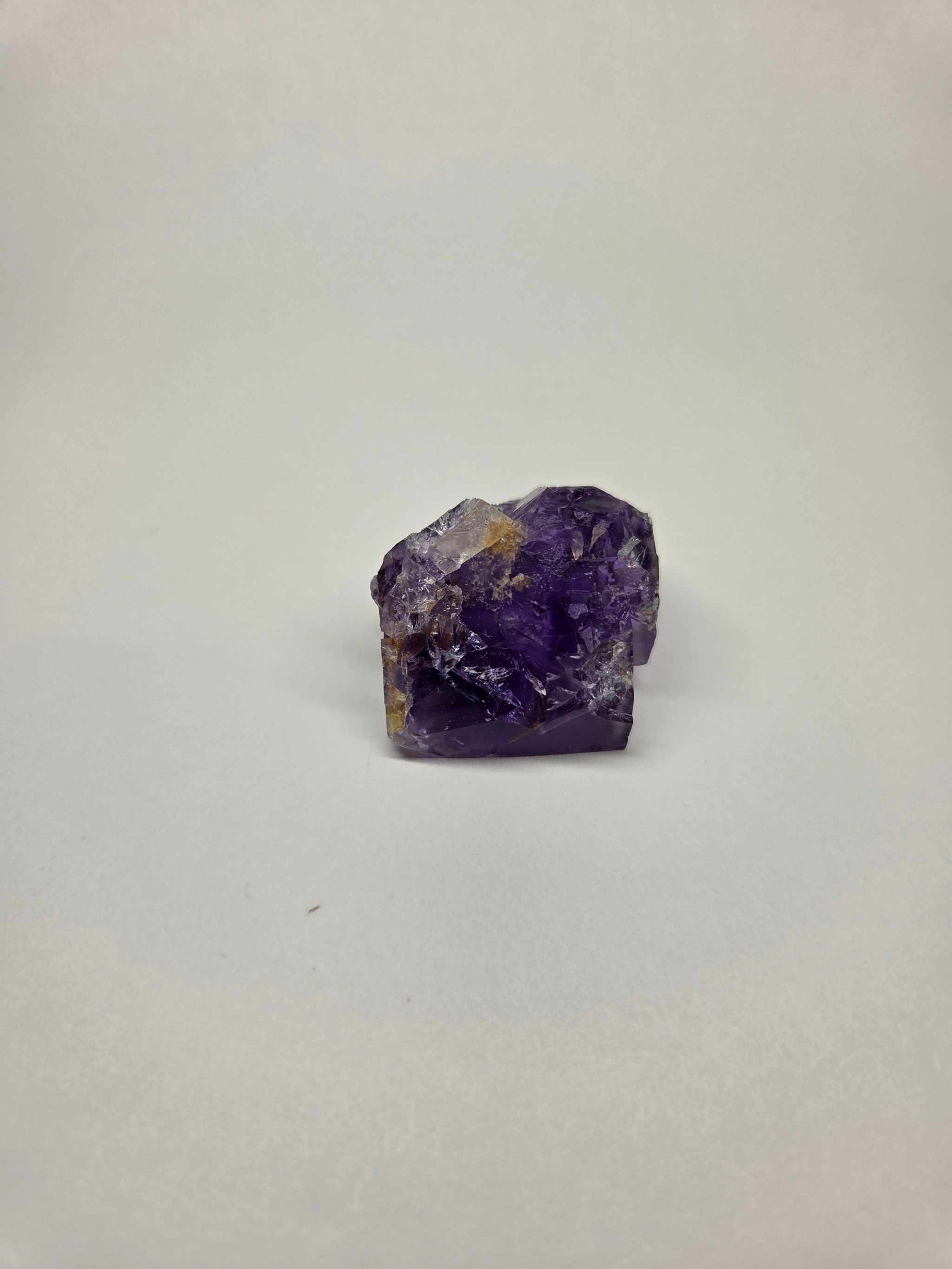 Purple Fluorite Specimen with smooth geometric side and rough luminous surface, ideal for crown and third eye chakra work.