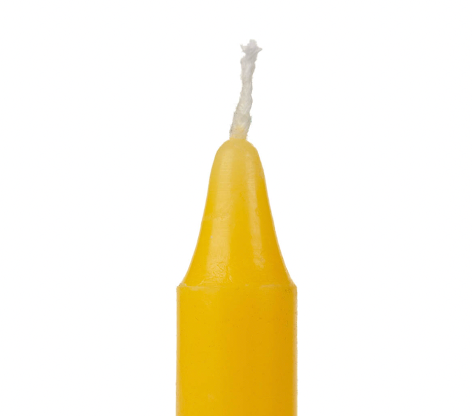 Yellow candle with a white wick on a white background